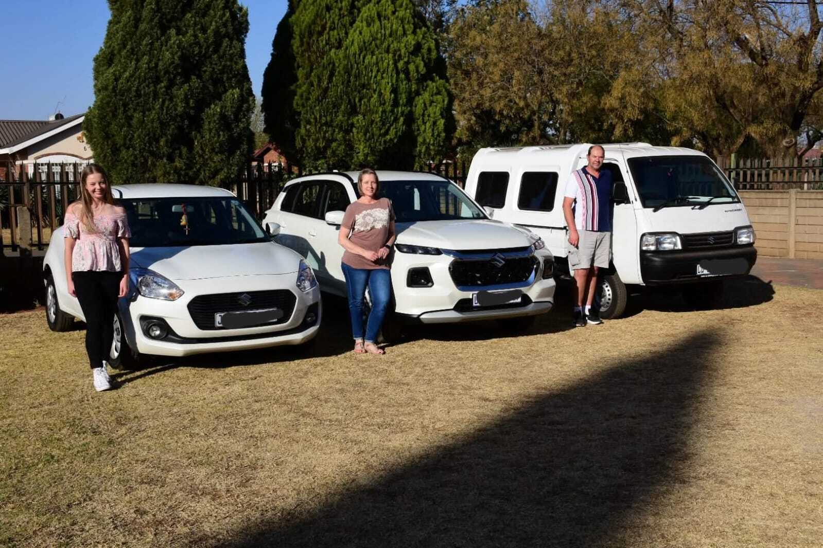 Suzuki Swift, Grand Vitara and Super Carry with people next to them,