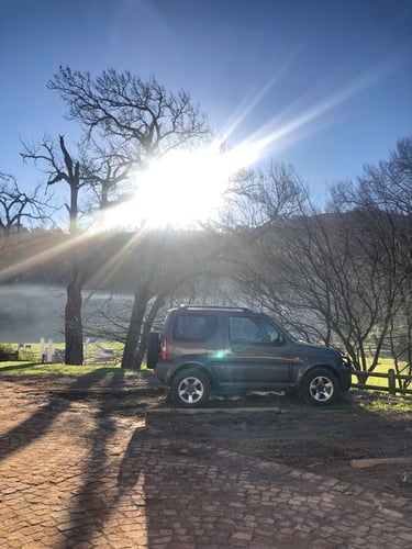 Suzuki Jimny in front of dam 