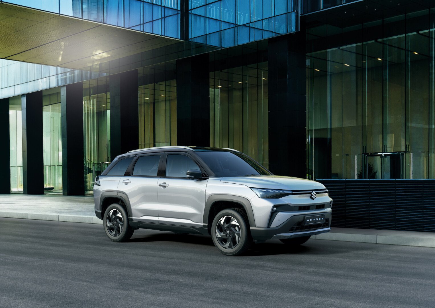 Silver Suzuki Across on the road in front of a building