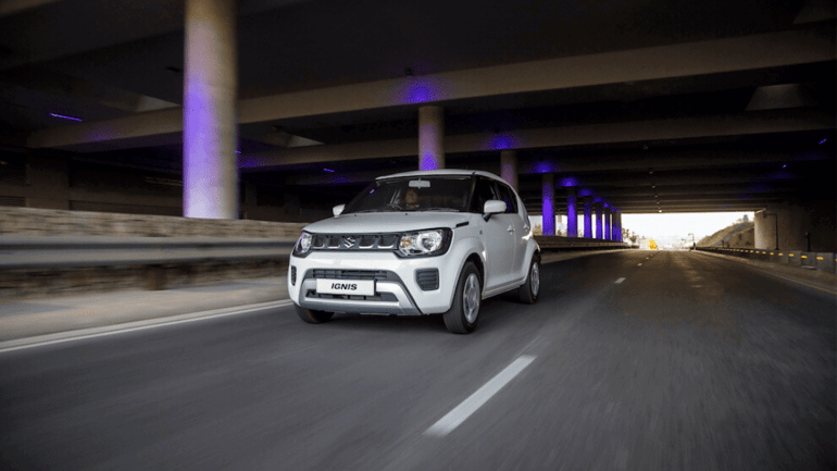 White Suzuki Ignis driving under bridge