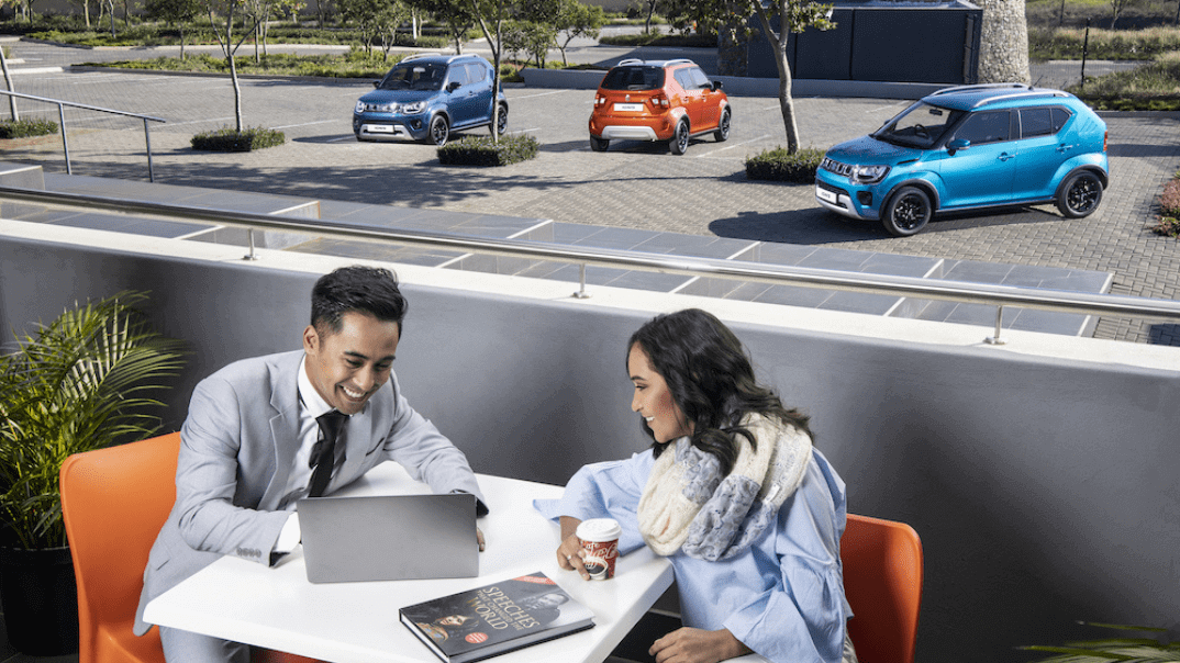 Suzuki Ignis in the background two people discussing work