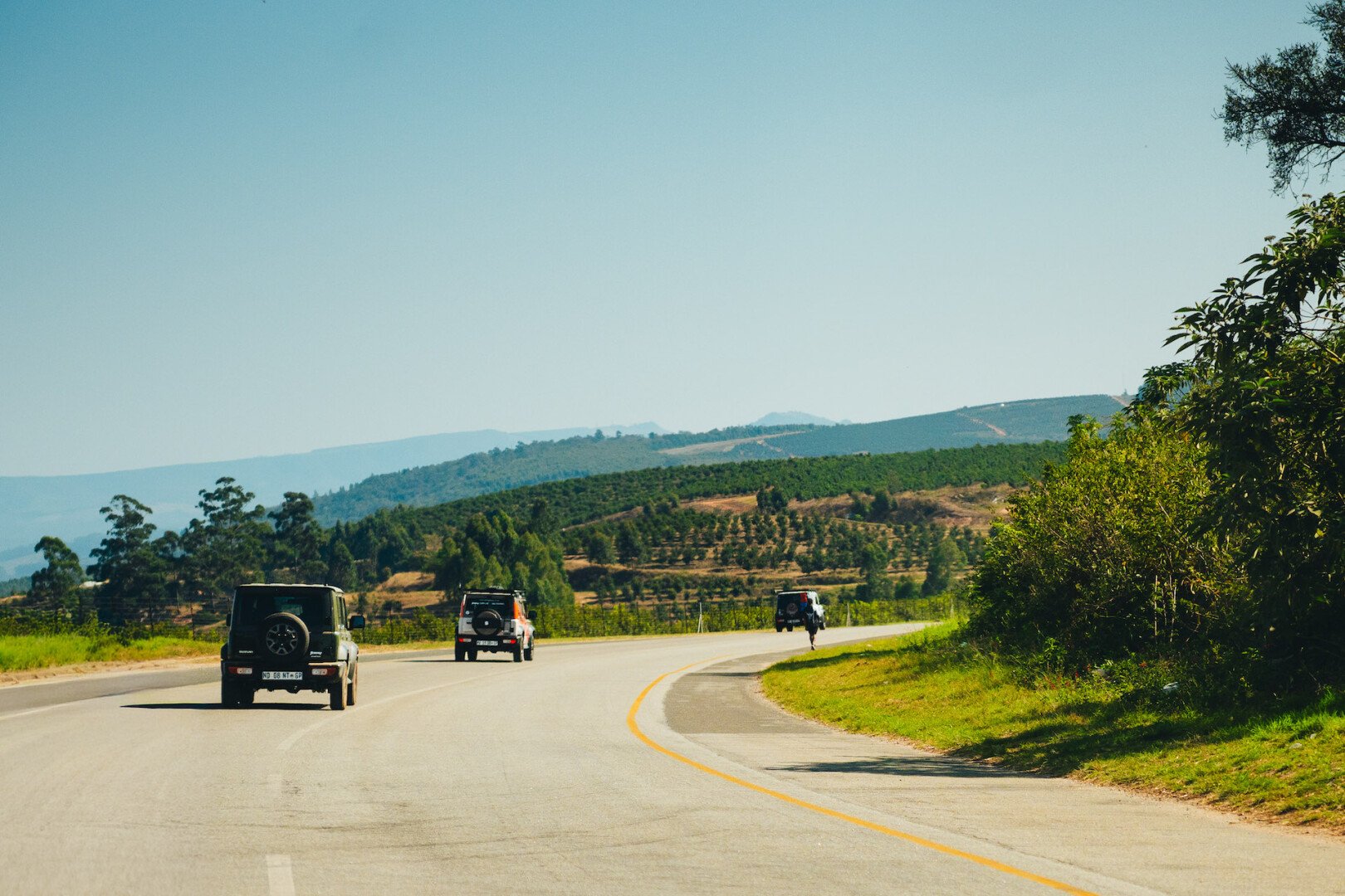 Suzuki Jimny's driving down the road