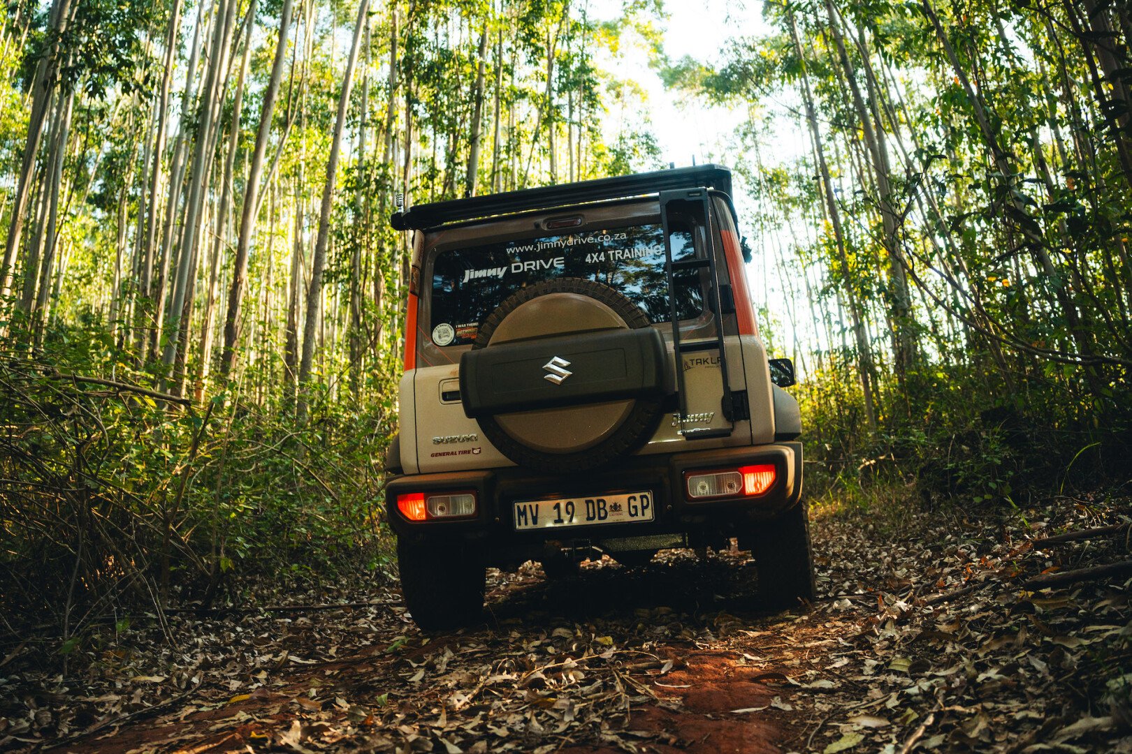 Jimny in the forest surrounded by trees