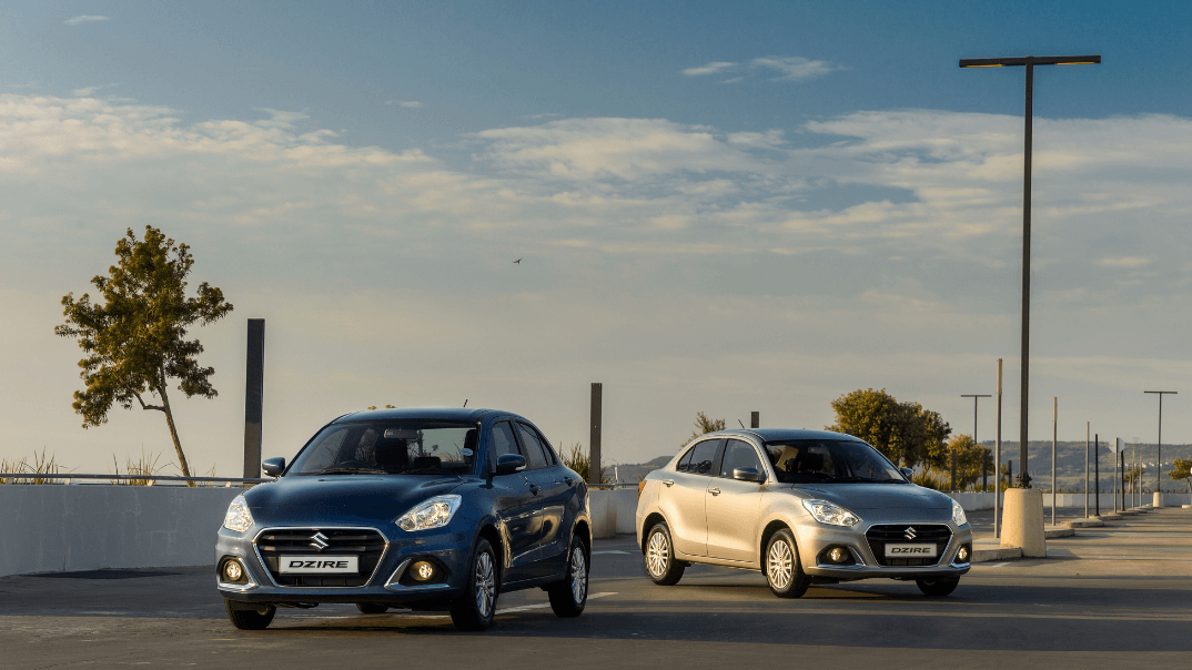 Suzuki Dzire Grey and blue parked on tar road