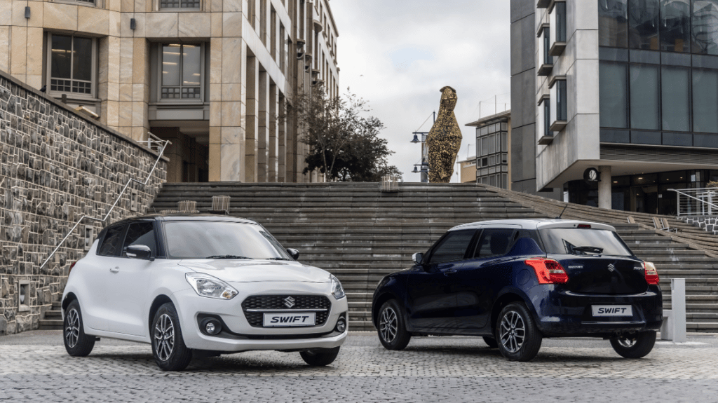 Two Suzuki Swift's parked behind stairs