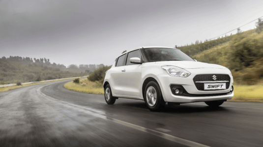 White Suzuki Swift Driving 