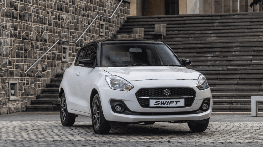 white suzuki swift parked in front of stairs