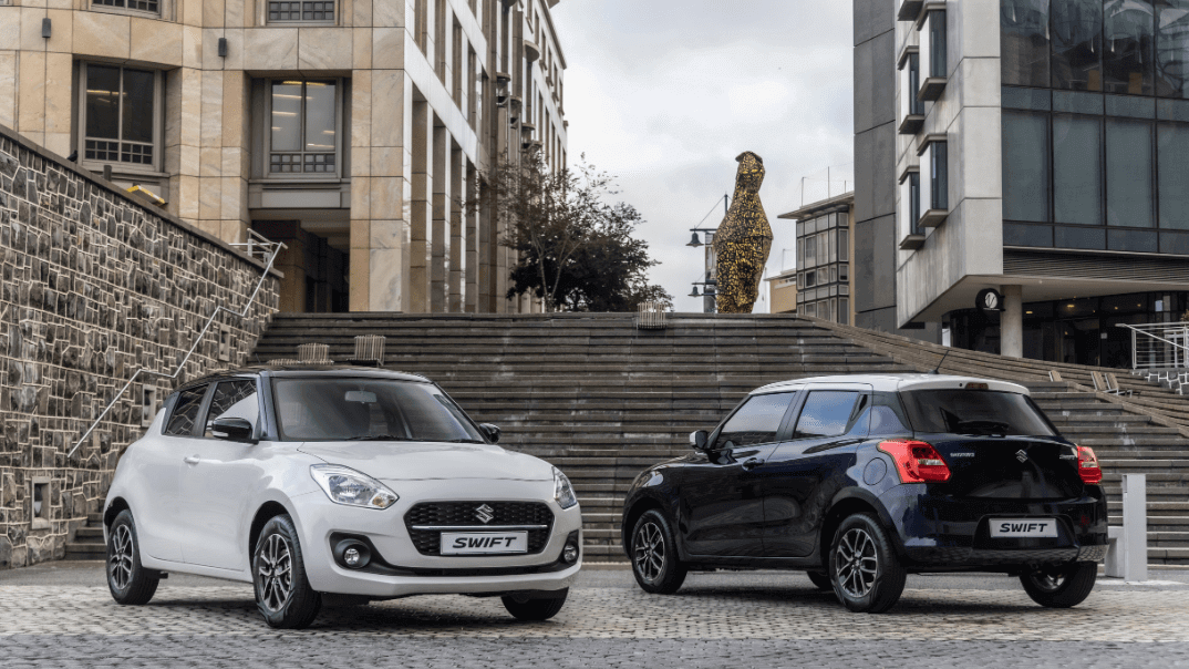 Two suzuki swifts in front of stairs