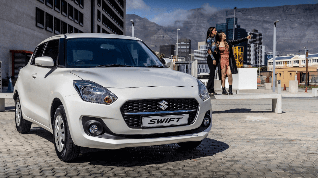white suzuki swift with people in the background