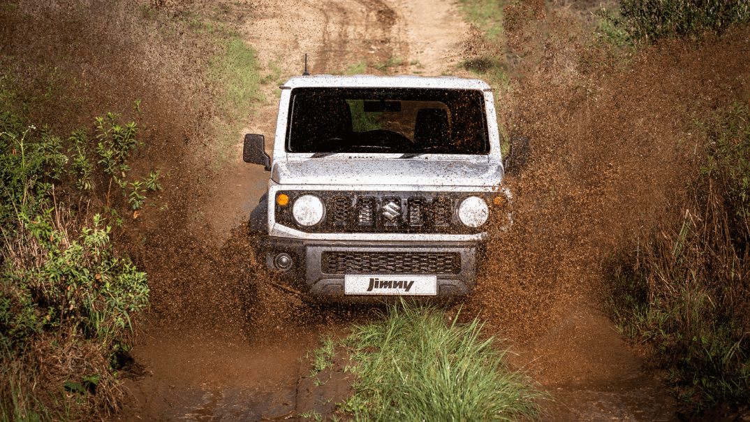 Suzuki Jimny driving on mud puddle