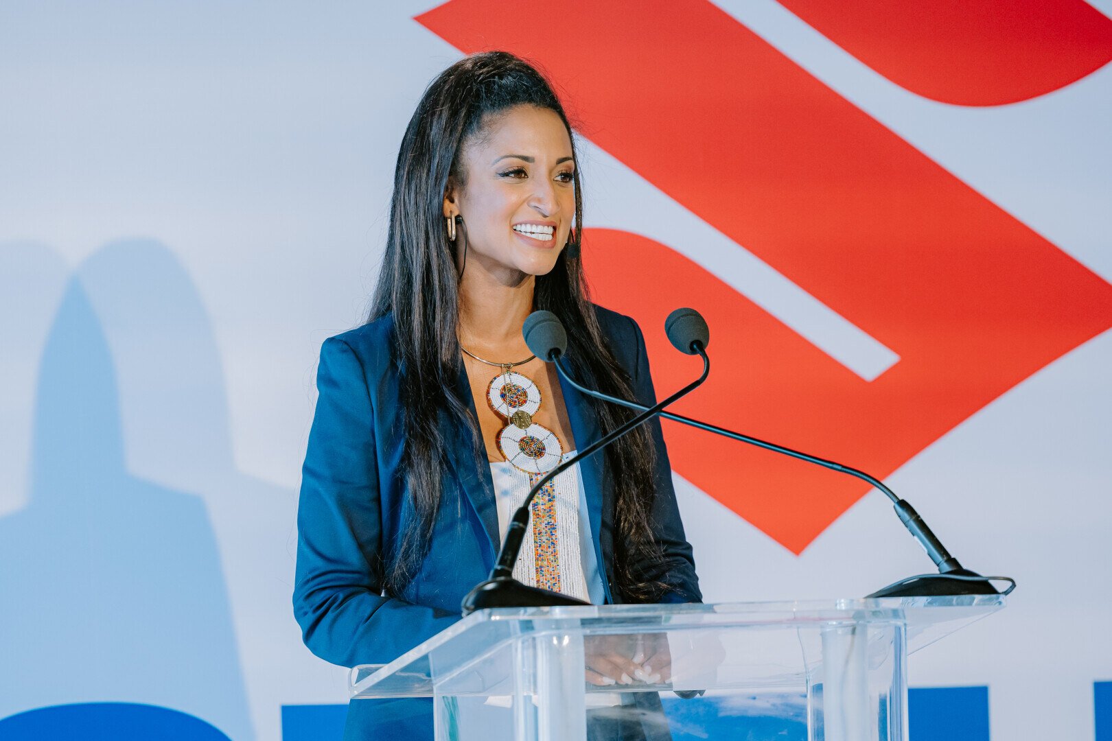 Woman speaking at a podium in front of Suzuki logo