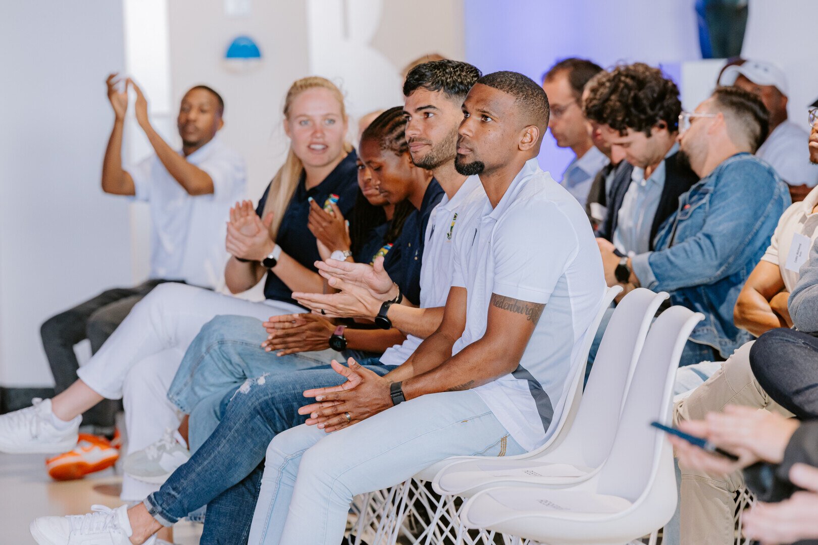 Audience members seated and clapping during an event