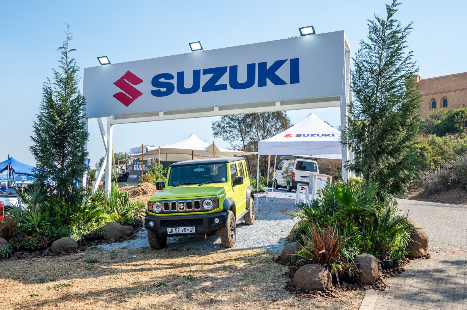 Suzuki Jimny under a Suzuki Billboard sign