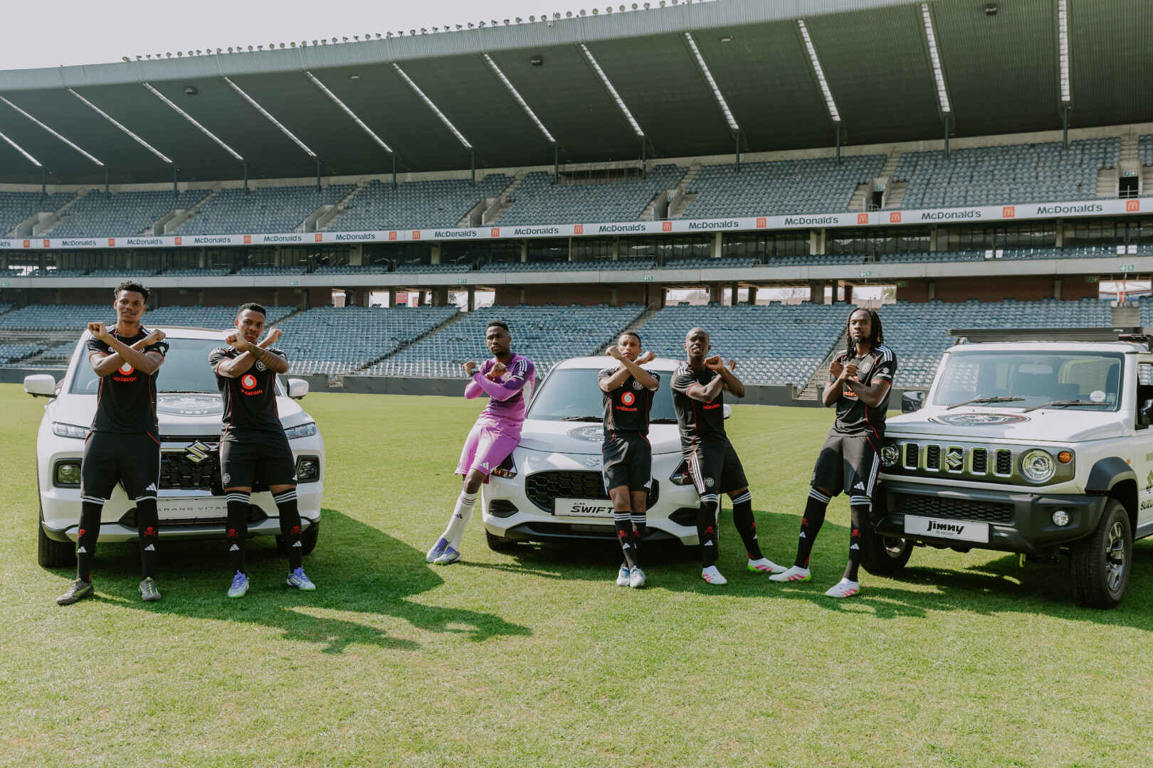Orlando Pirates team members in front of Suzuki Vehicles 