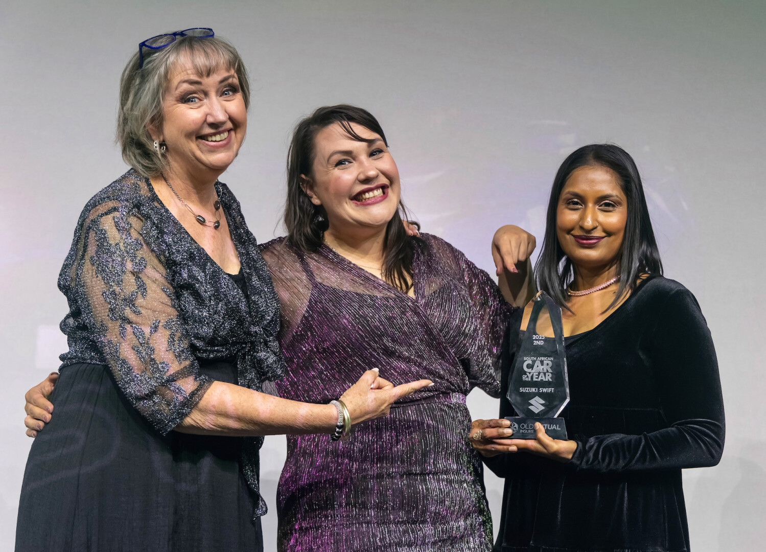 Three women holding an award 