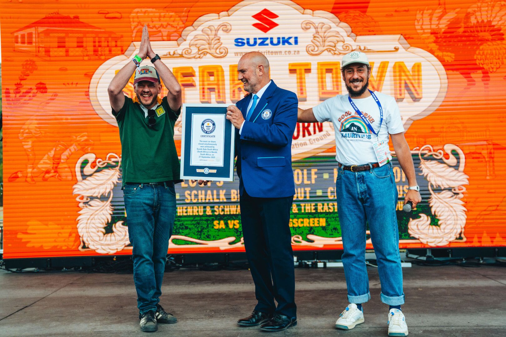 Three men cheering and one holding the guiness world record award